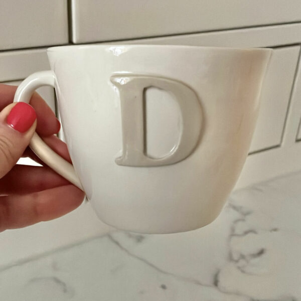 Beige kopp bokstav D