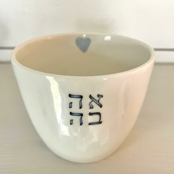 Vit porslinsmugg med tre hebreiska bokstäver som bildar ordet "ahava" (kärlek), samt ett litet hjärta på insidan av koppen.