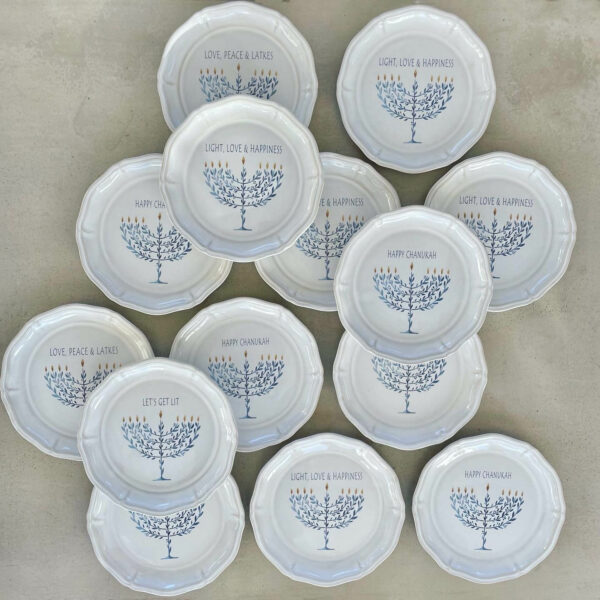 Handgjorda Chanukah-assietter i stengods med blå menorah och textvariationer som ”LOVE, PEACE & LATKES”, ”LIGHT, LOVE & HAPPINESS”, ”HAPPY CHANUKAH” och ”LET’S GET LIT” – perfekta för festliga dukningar.