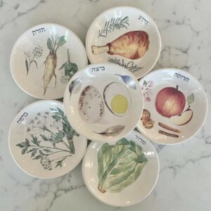 Sex små stengodsfat med illustrationer av sederkvällens symboliska rätter