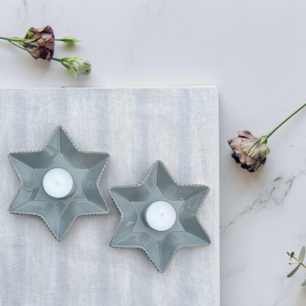 Stjärnformade ljushållare i keramik med 22k guld 1 Två stjärnformade ljushållare i gråblå keramik med 22k gulddetaljer, perfekta för Shabbat och festdukning