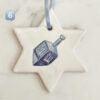 Handgjort keramikhänge i form av Davidsstjärna med blått band – dekorerat med blå dreidel